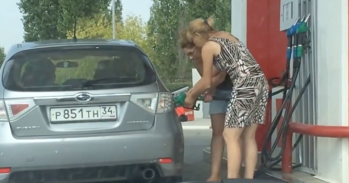 O esforço de duas mulheres para conseguir abastecer o carro
