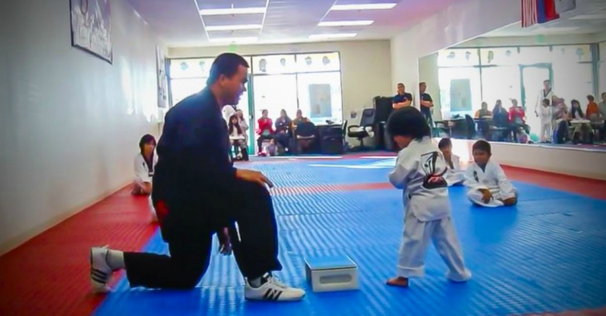 Menino tenta partir placa de madeira para conseguir a sua primeira faixa no Taekwondo