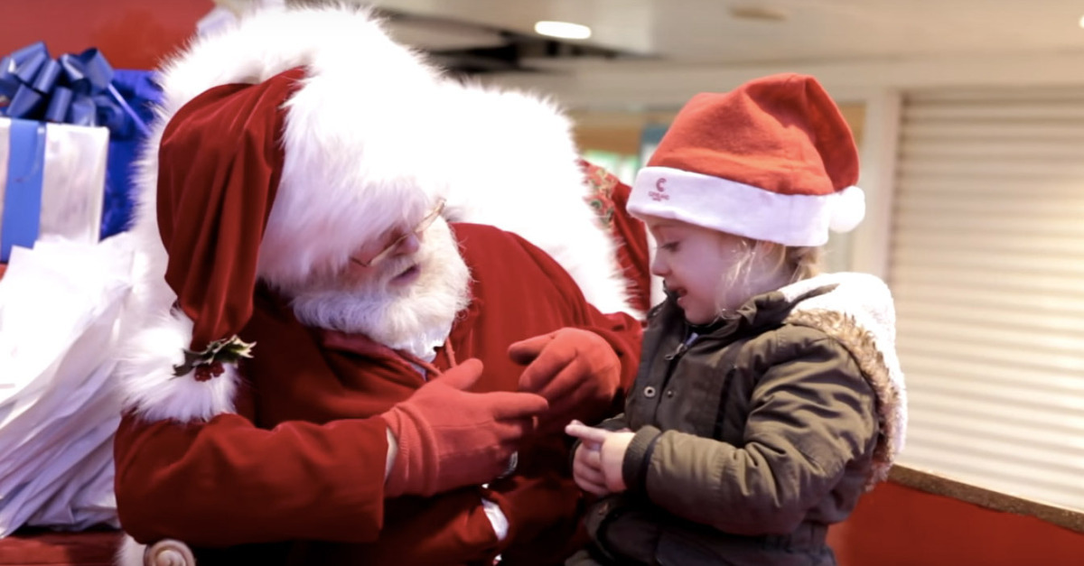 Pai Natal comunica com criança utilizando língua gestual