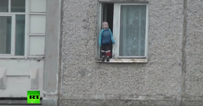 Bebé russo brinca no parapeito da janela do 8º andar
