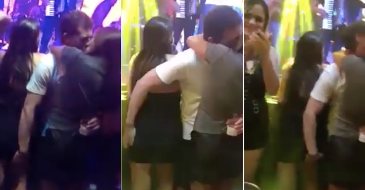 Homem beija mulher e apalpa outra ao som do tema De Mãos Atadas
