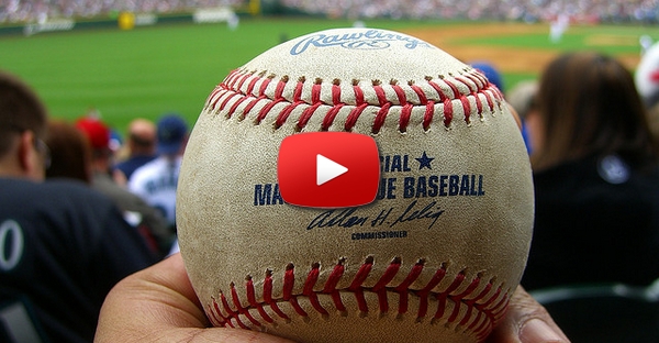 Um rapaz encanta a rapariga num jogo de baseball.